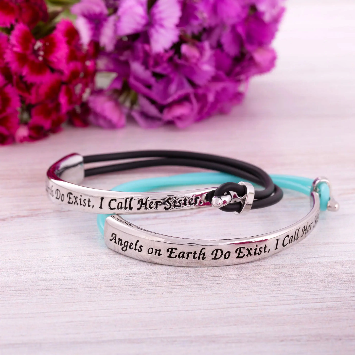 Silver-toned sisters are angels on earth bracelet with engraved text and black and teal cord accents