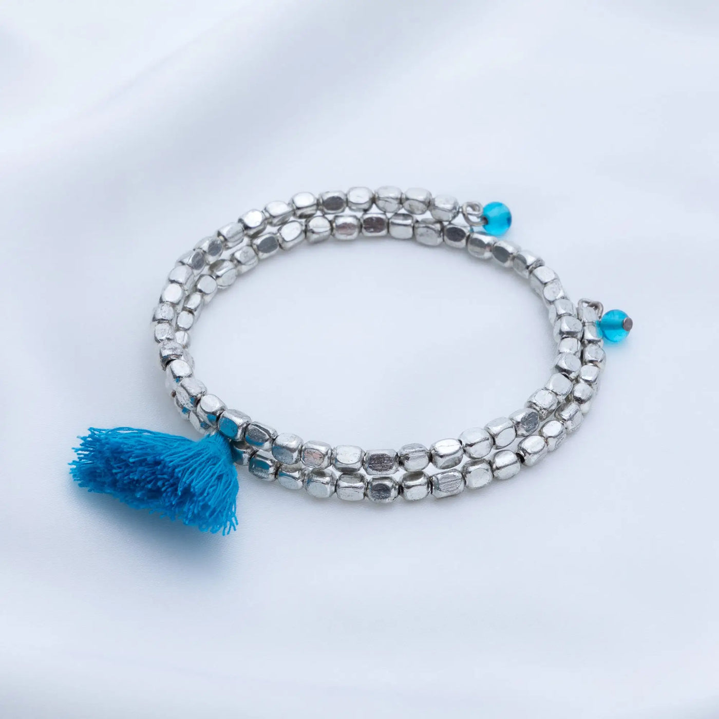 Silver beaded taj tassel bracelet with vibrant blue tassel and matching turquoise accent beads