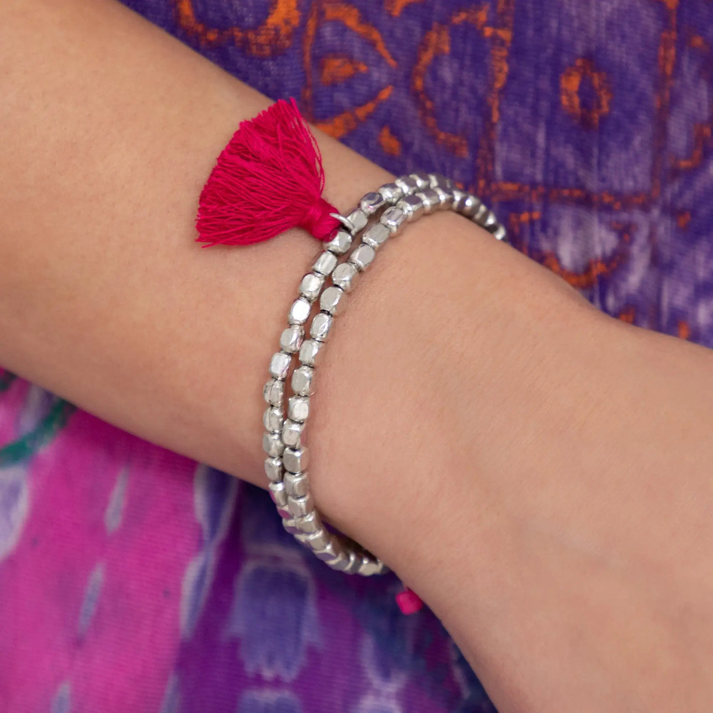 Silver beaded taj tassel metal bead bracelet with a vibrant red tassel accent for stylish wear