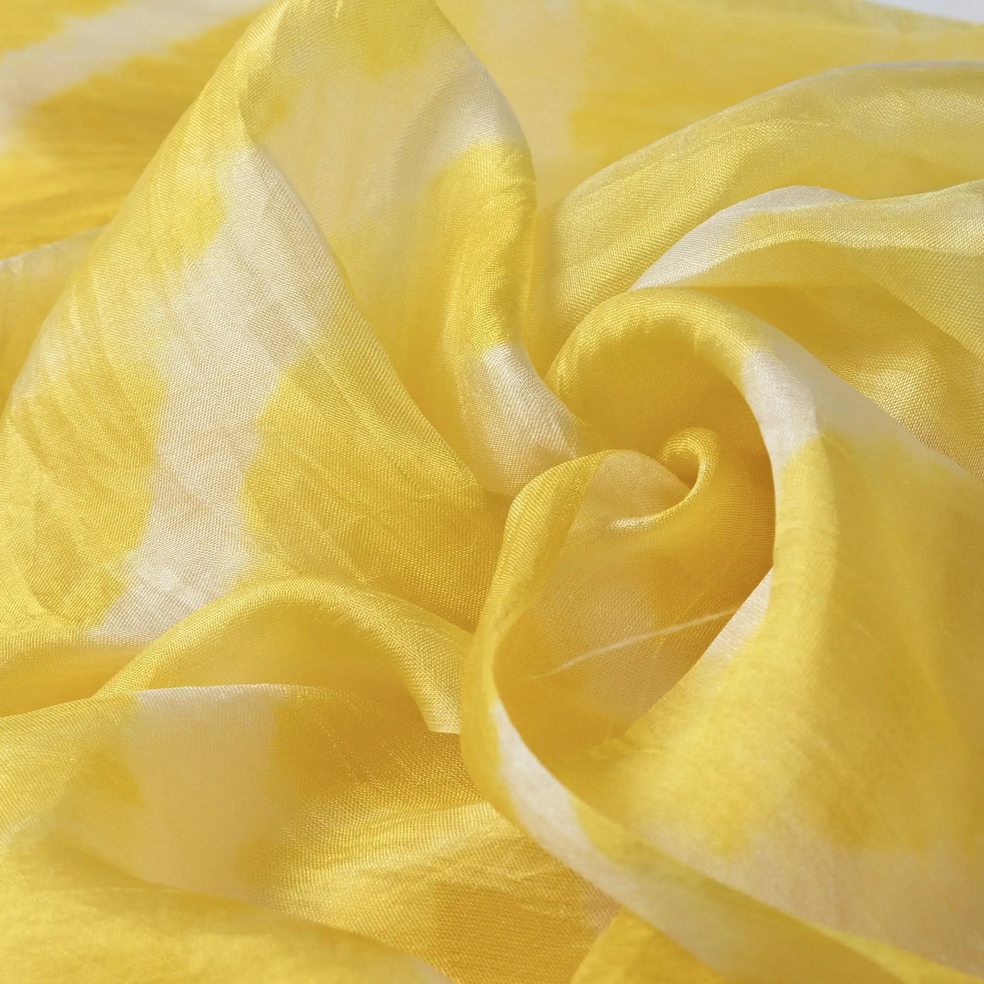 A delicate yellow and white tie-dye stripe silk scarf with soft flowing folds for elegant wear