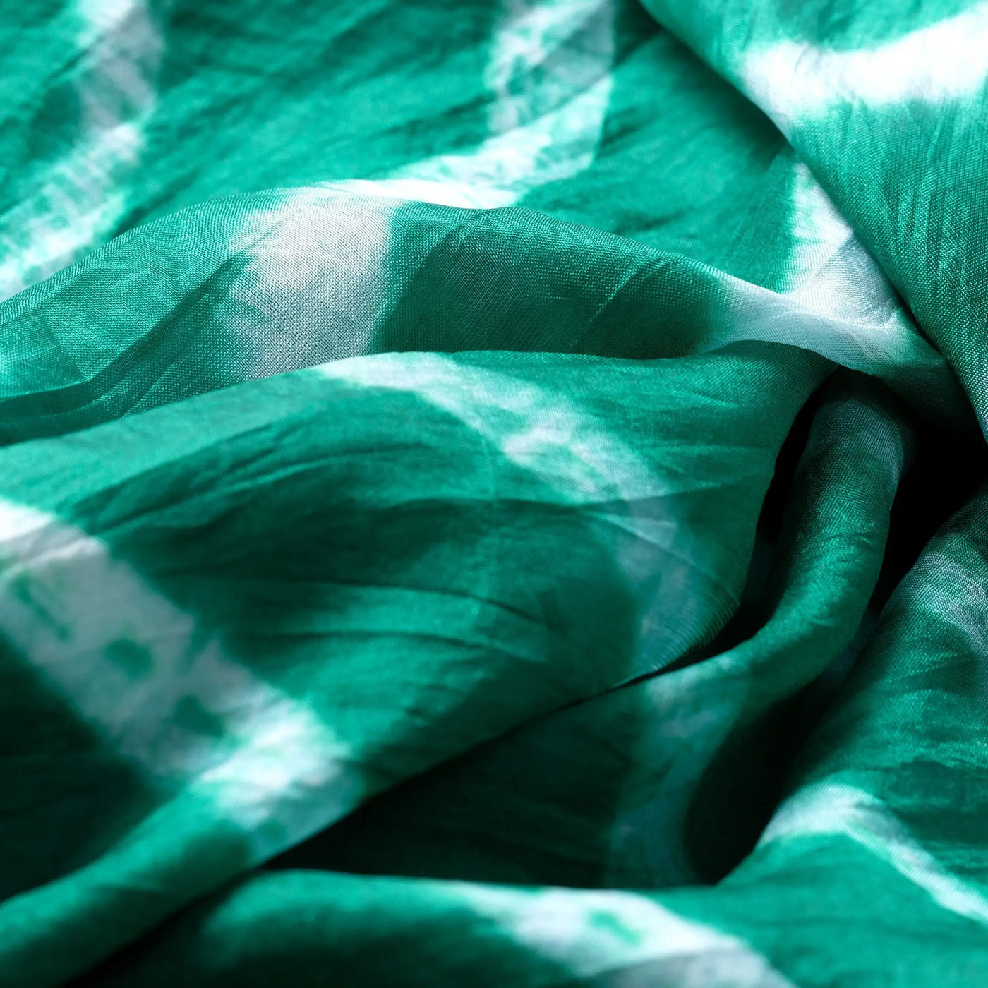 A soft flowing green and white tie-dye silk scarf with a silky texture perfect for stylish wear