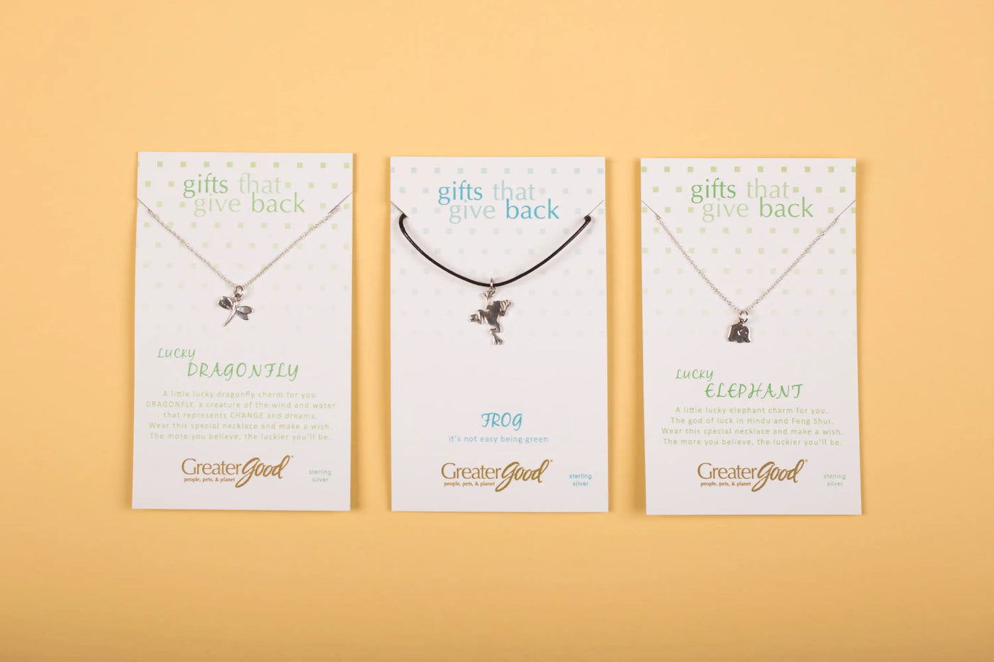 Three silver-toned sterling wild at heart necklace pendants shaped as dragonfly frog and elephant on greatergood cards
