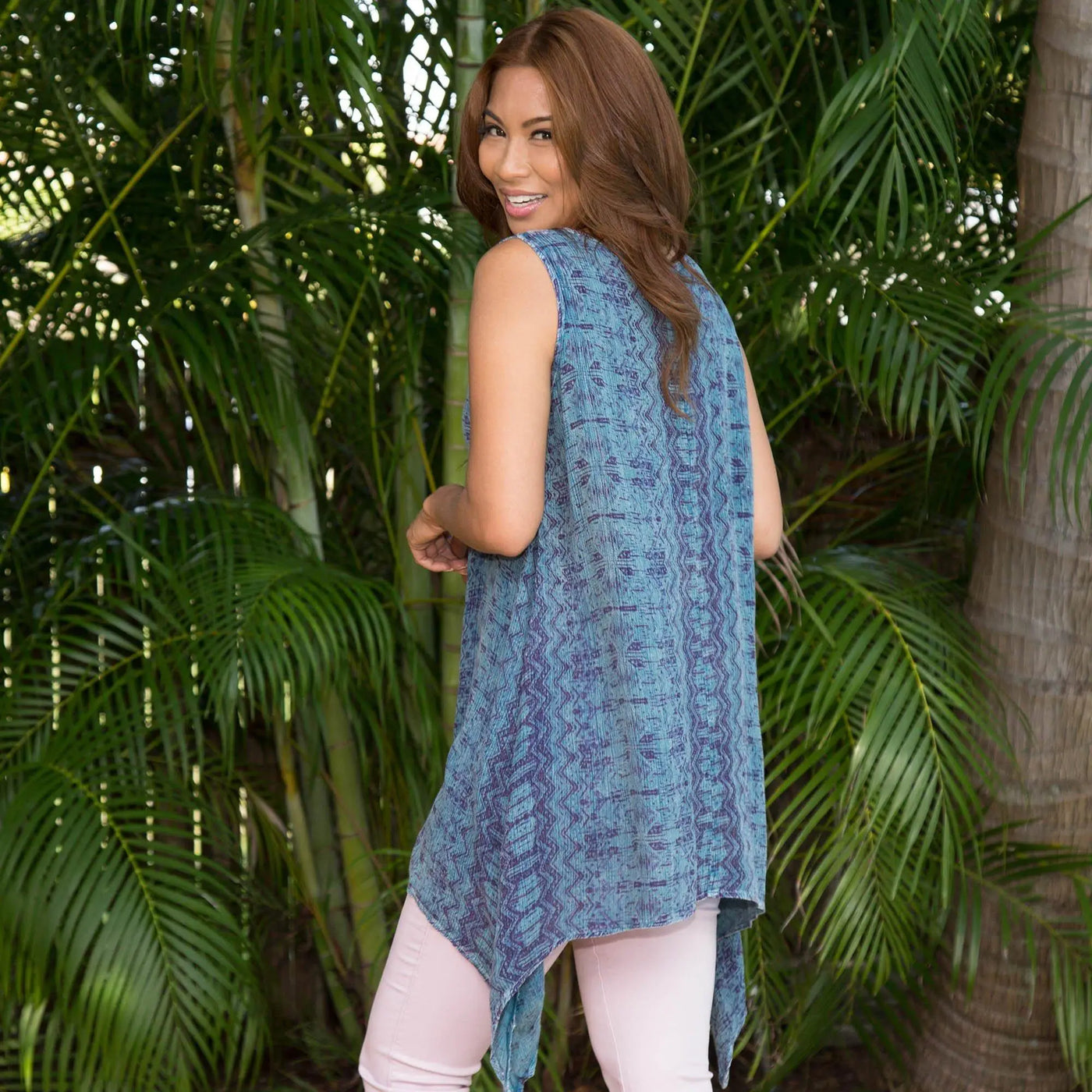 A blue patterned sleeveless tunic with embroidery and an asymmetrical flowing hemline center lane style