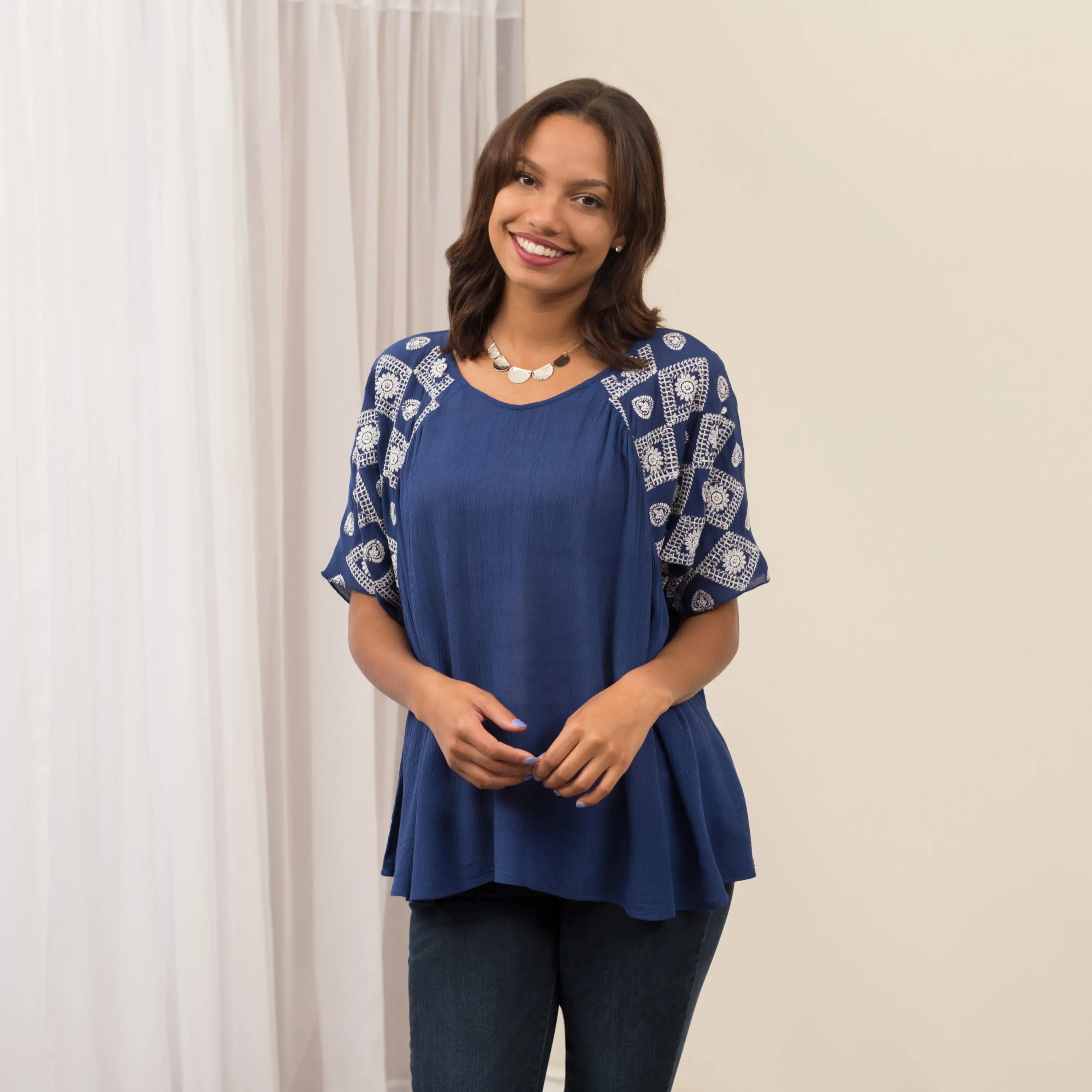 Blue top with white geometric embroidery on sleeves and neckline featuring a peplum hem diamonds on my sleeve top