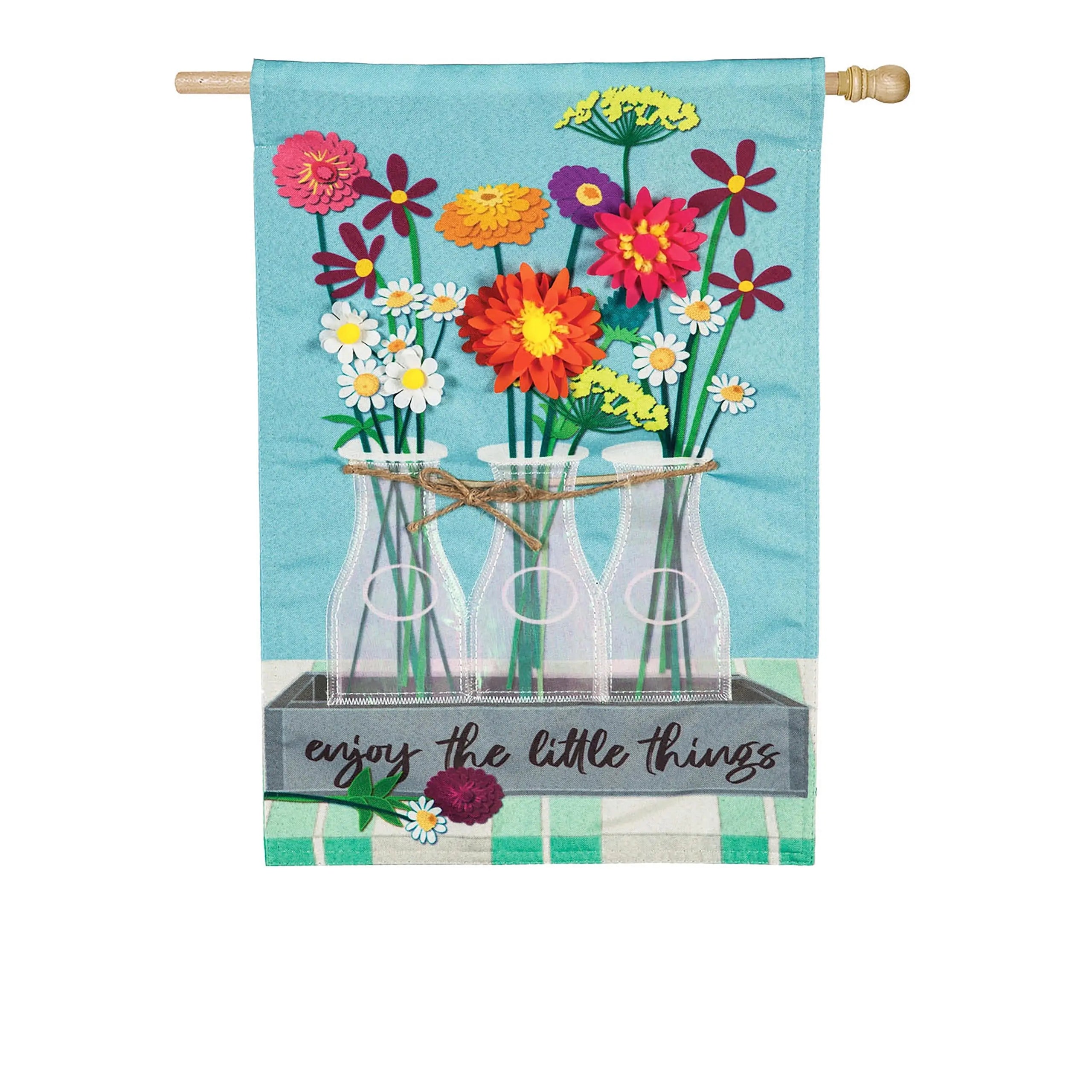 Floral milk bottle trio house linen flag with colorful paper-cut flowers in glass bottles tied with twine on blue background