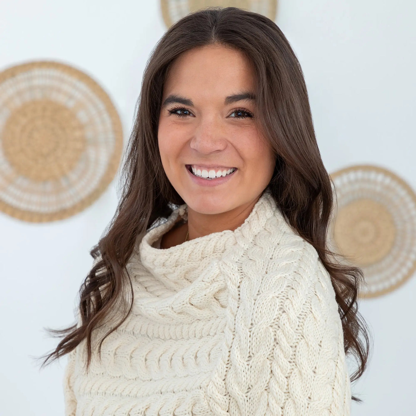 Cream-colored cable-knit sweater with high ribbed neckline made from irish aran wool for cozy warmth