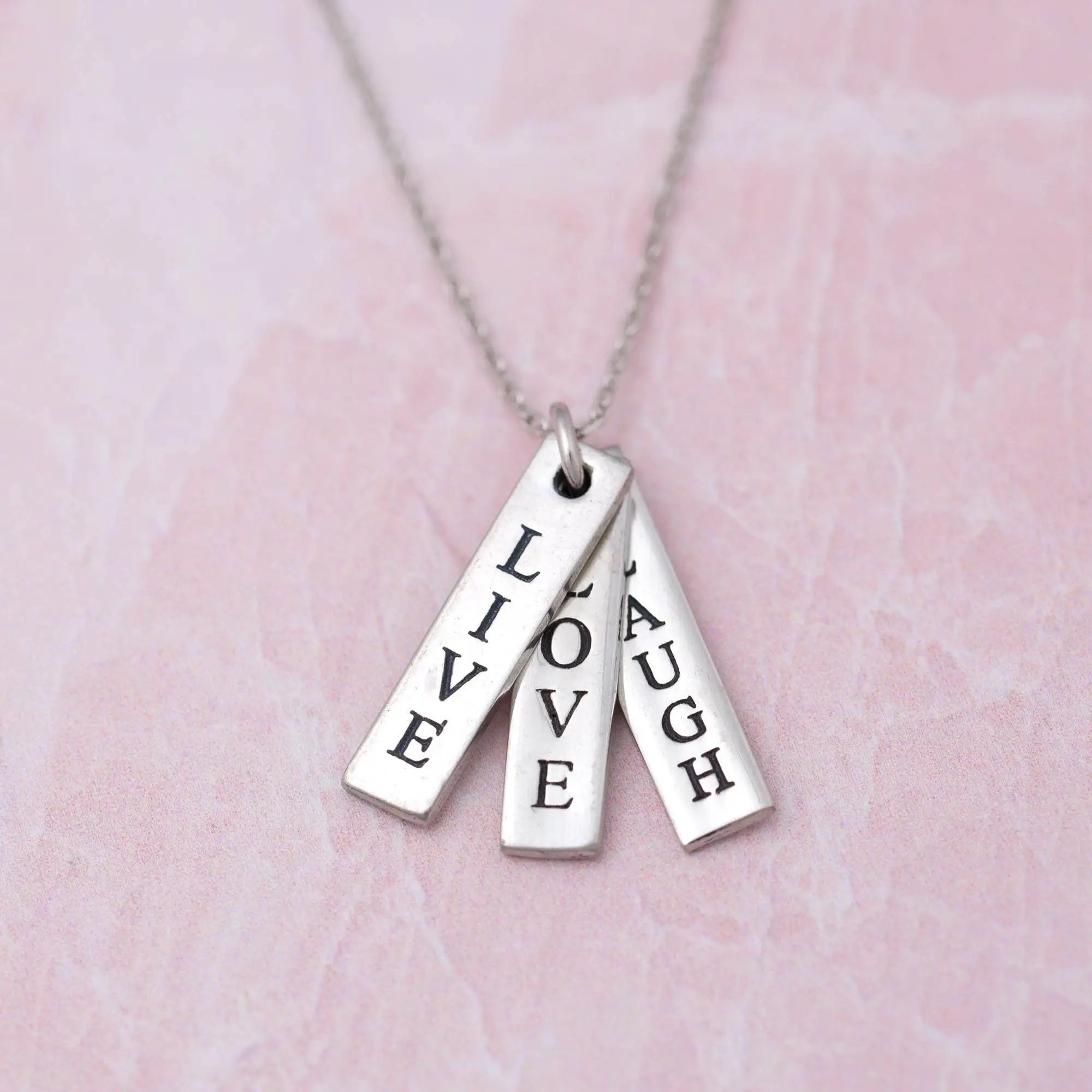 Silver live love laugh pewter necklace featuring three engraved rectangular tags with inspirational words