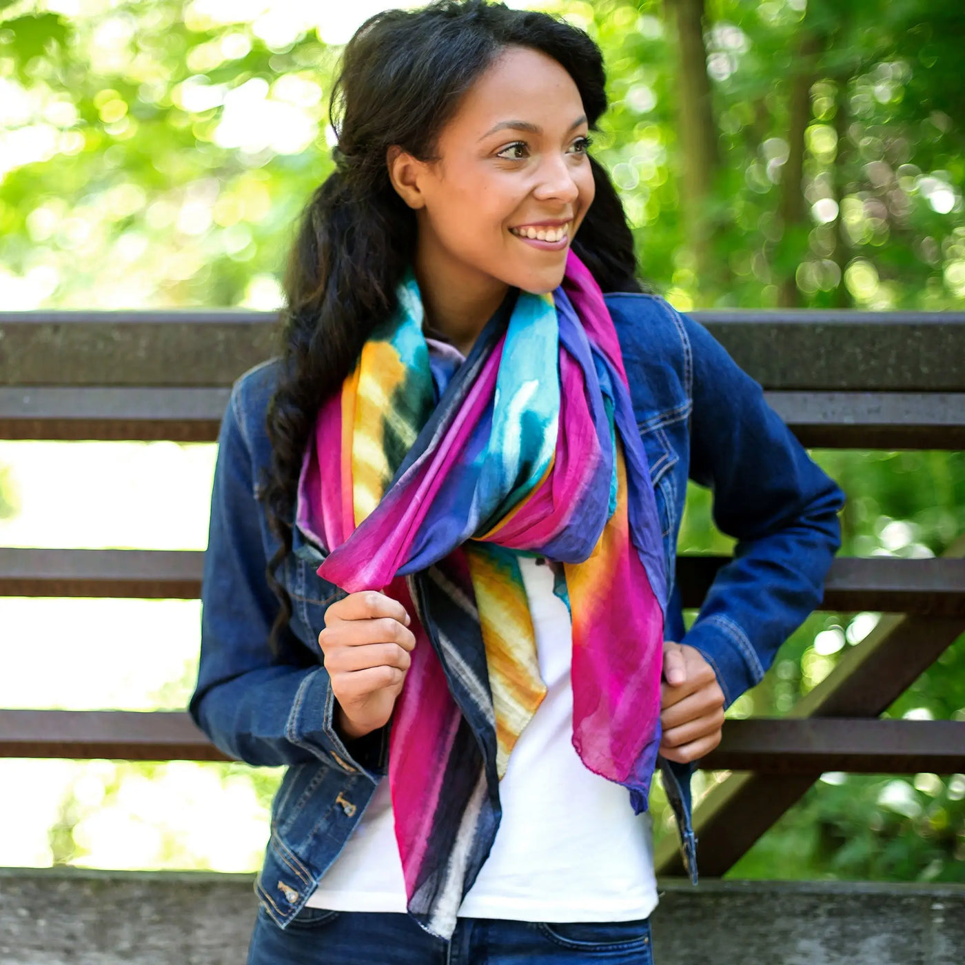 A vibrant multicolored northern lights cotton scarf with a pink blue yellow and purple tie-dye pattern fair trade