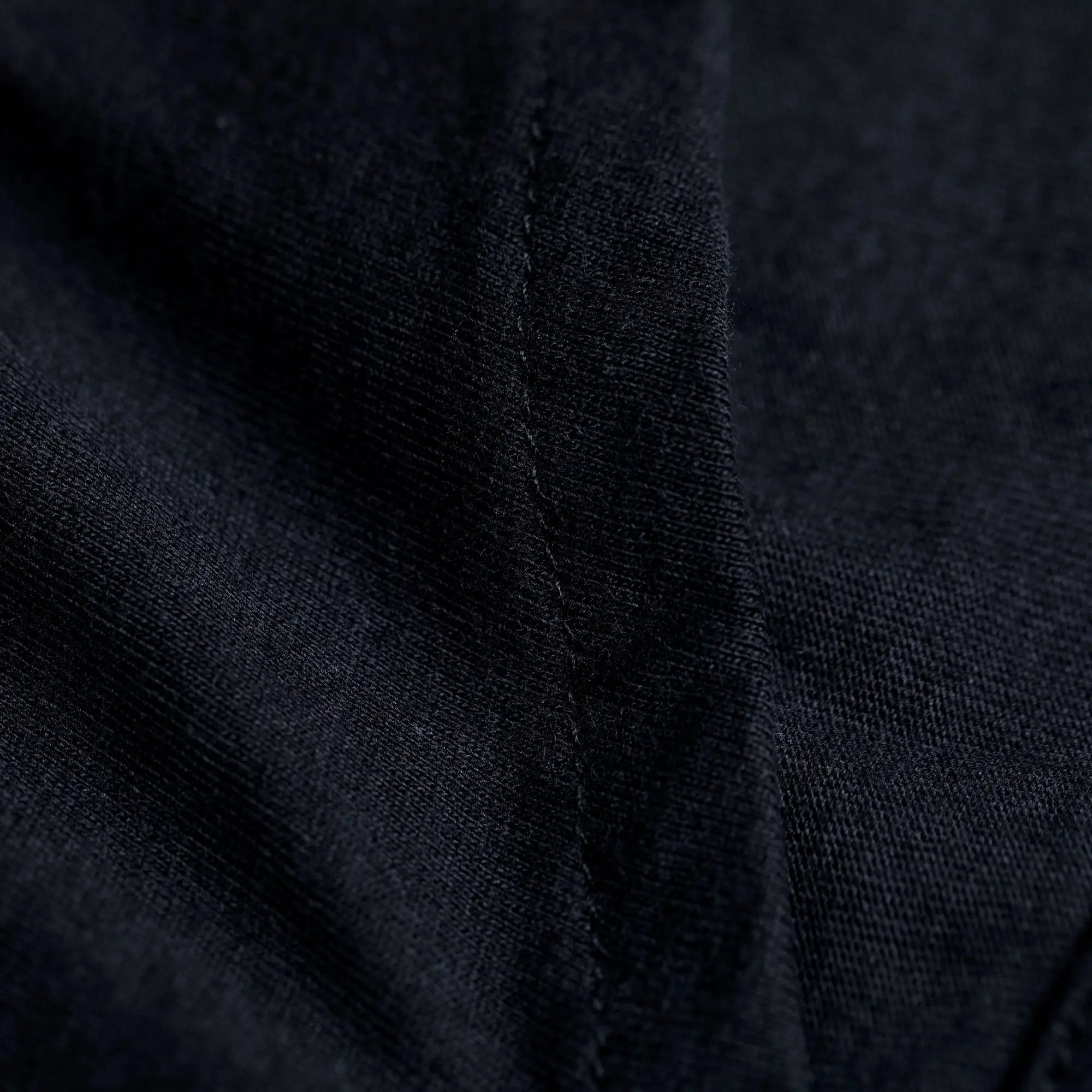 Black textured organic layered pencil skirt fabric with visible stitching close-up detail