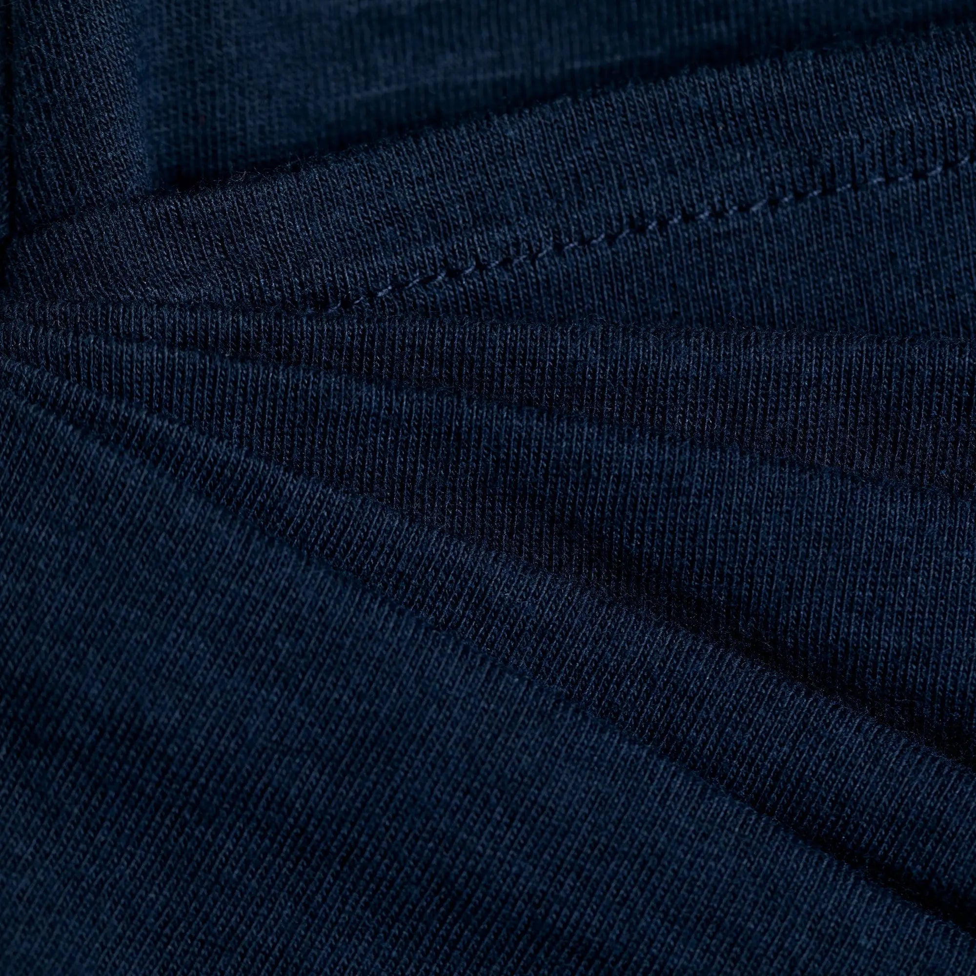 Dark blue ribbed knit organic layered pencil skirt showing visible stitching along the seams
