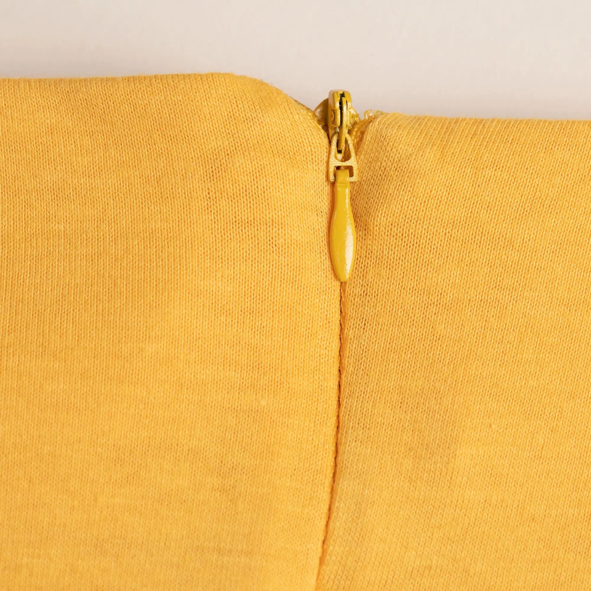 Organic layered pencil skirt featuring a yellow zipper with matching pull tab on textured mustard fabric