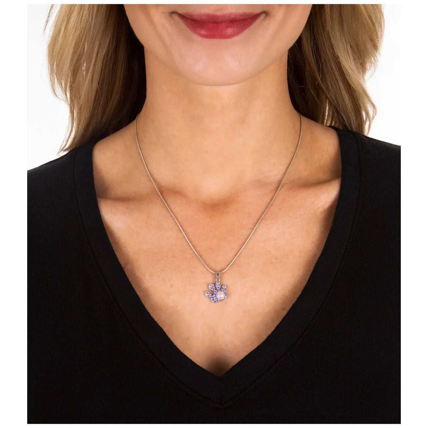 A delicate sterling silver necklace with a purple paw print pendant featuring sparkling stones and a central pearl