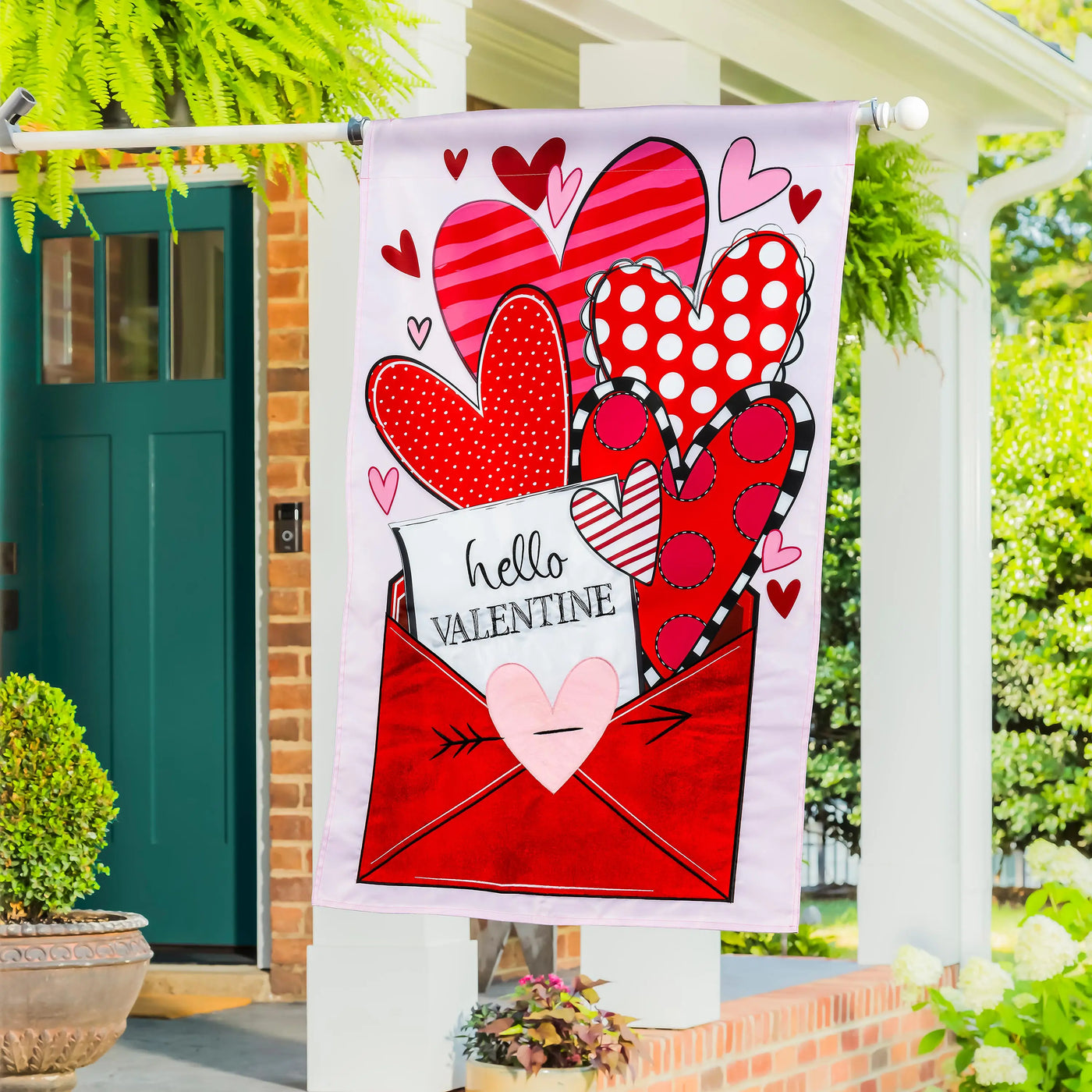 A vibrant sending love valentine’s day applique house flag with a red envelope and colorful patterned hearts