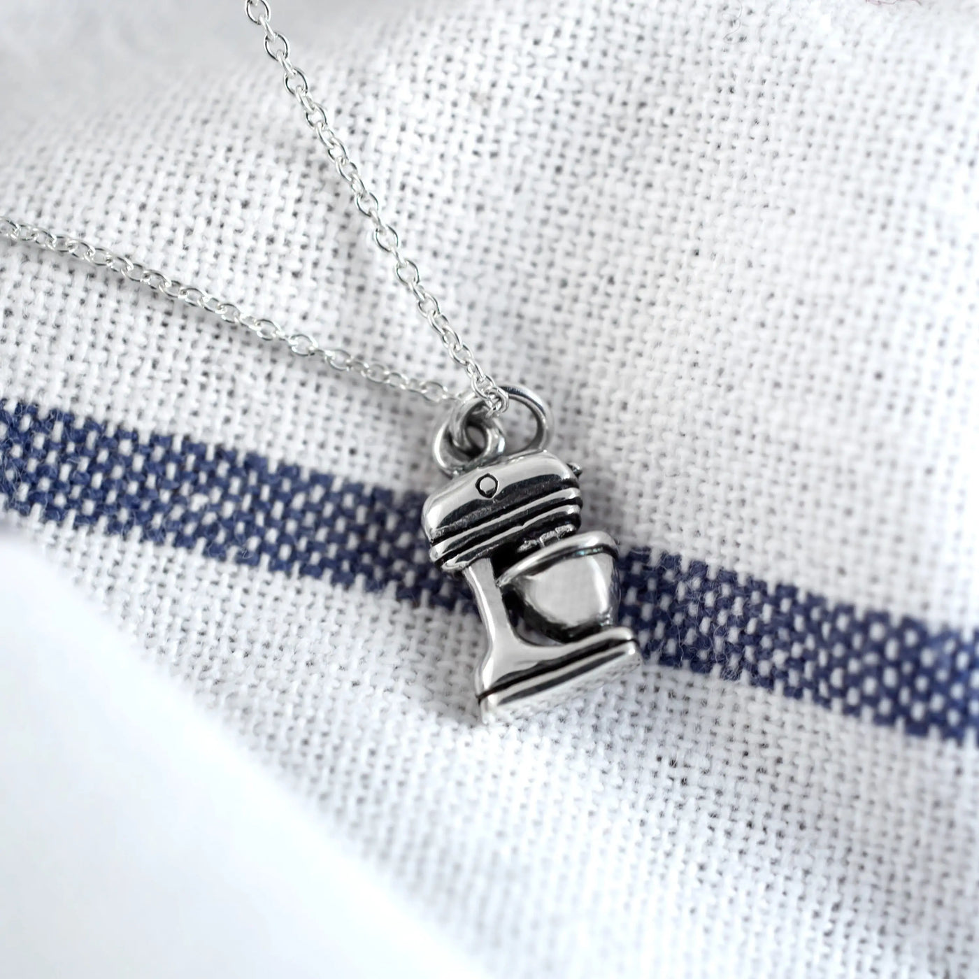 Silver-colored sterling necklace pendant shaped like a miniature stand mixer on a delicate chain