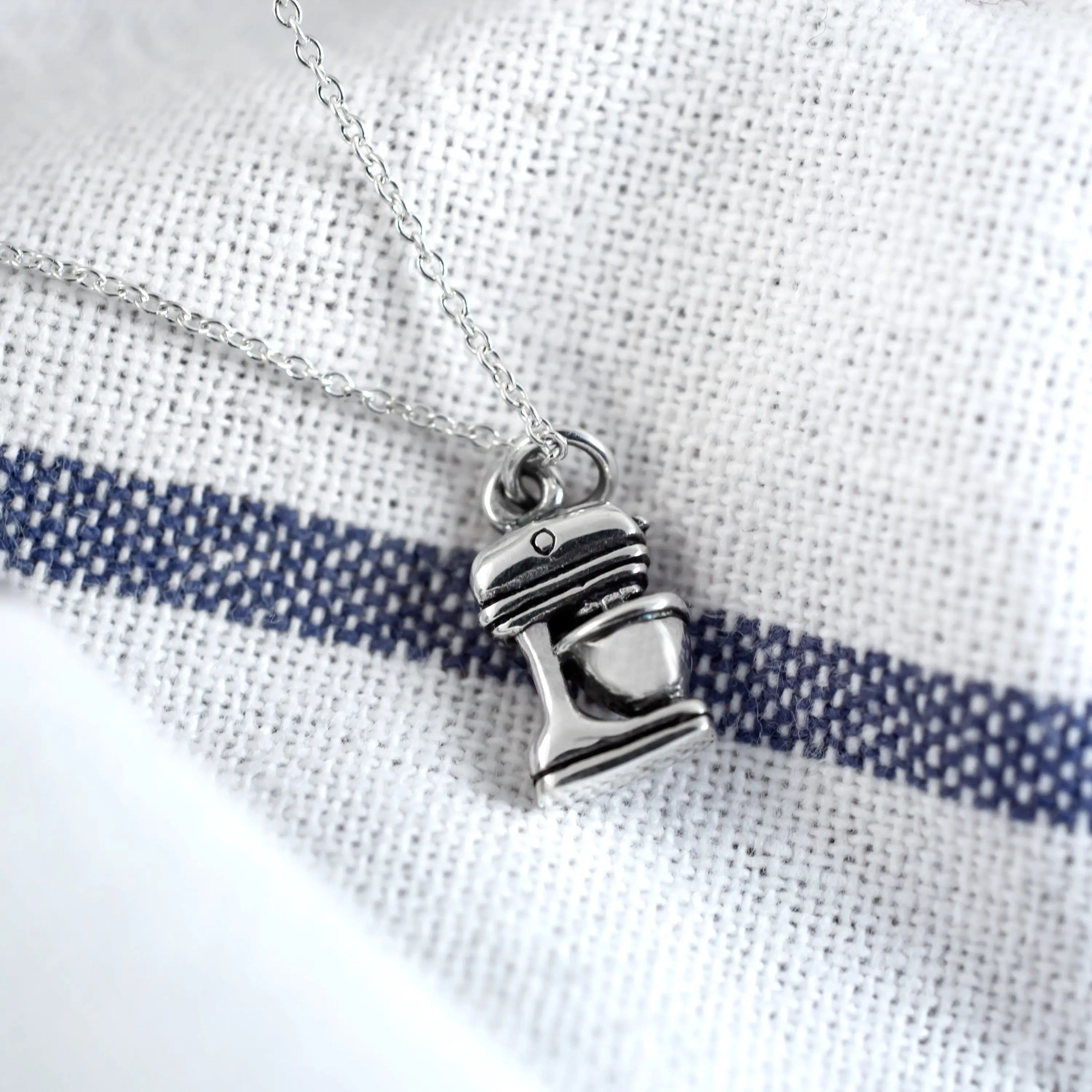 Silver-colored sterling necklace pendant shaped like a miniature stand mixer on a delicate chain