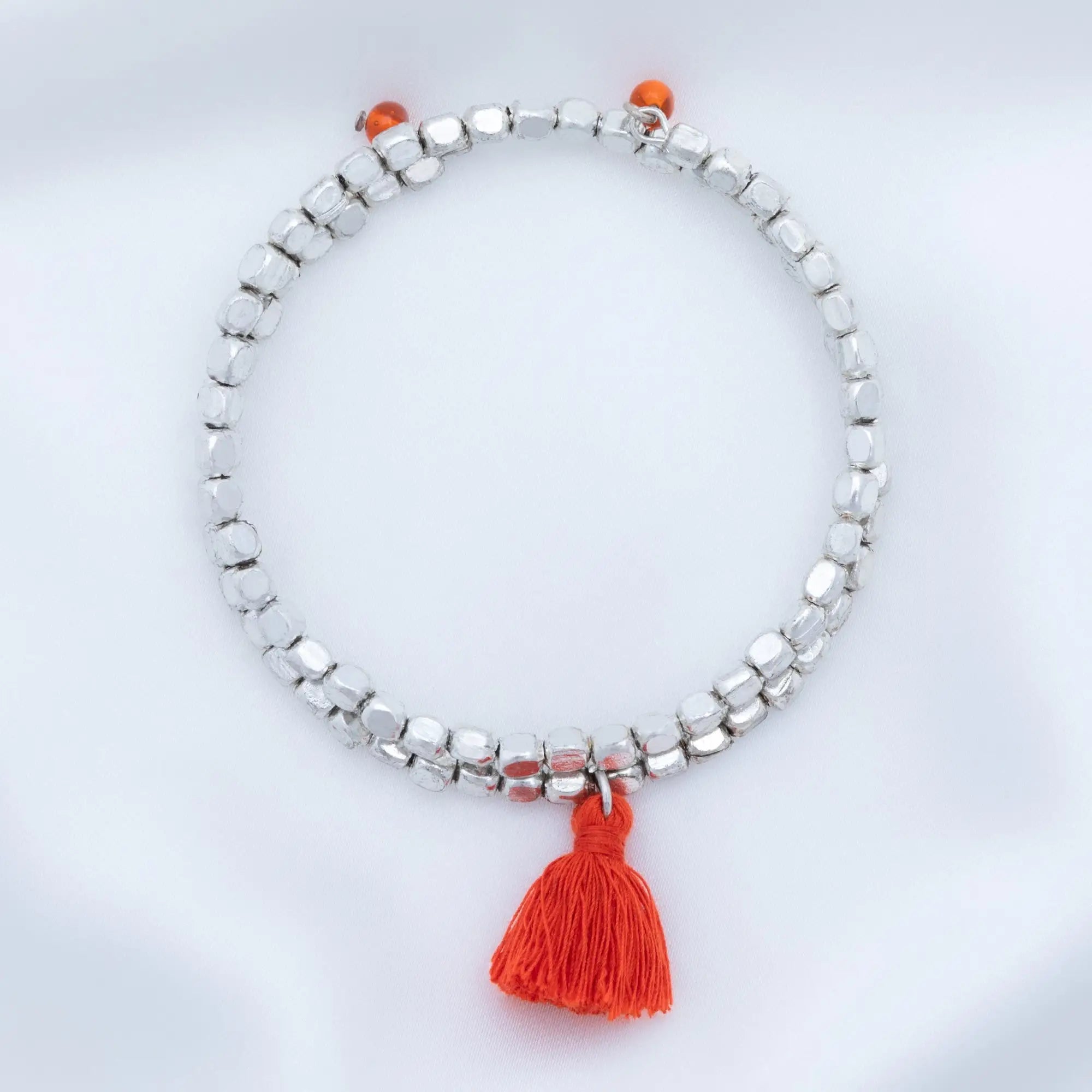 Silver beaded taj tassel metal bead bracelet with a vibrant orange tassel charm for stylish wear