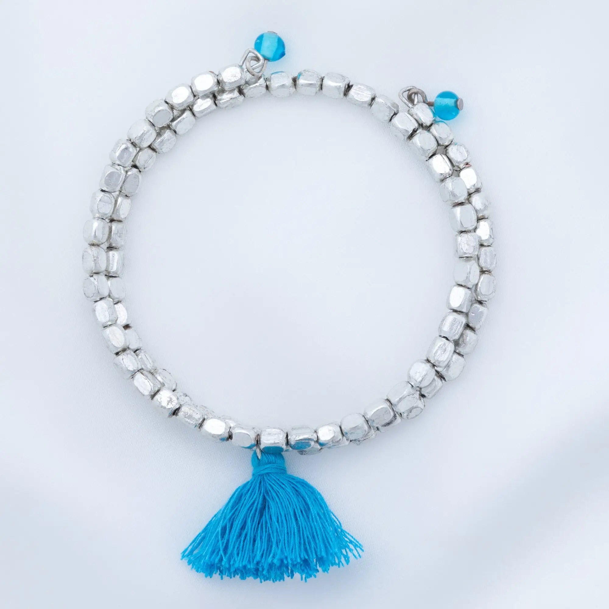 Silver beaded bracelet with vibrant blue tassel and turquoise accent beads from taj tassel metal bead bracelet collection