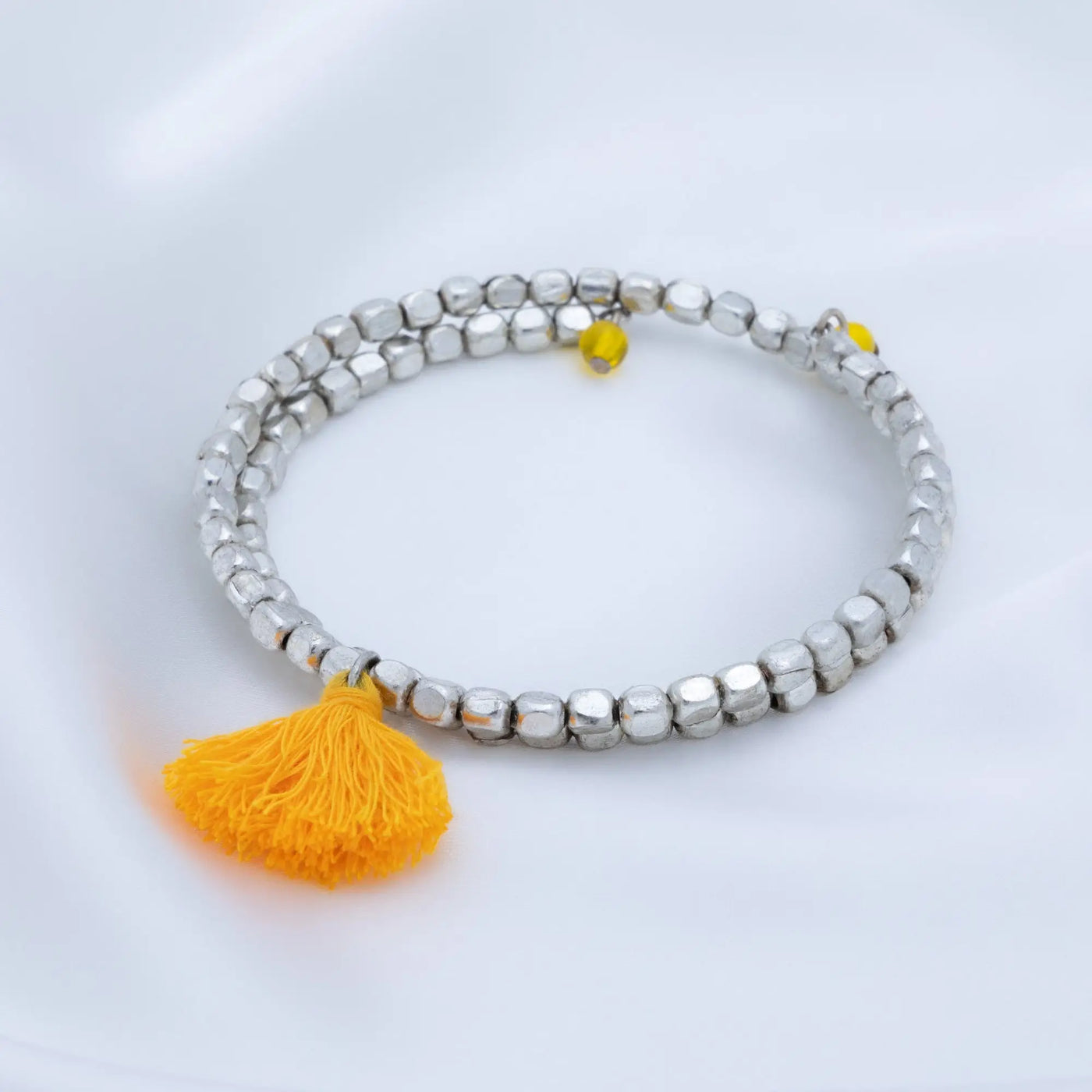 Silver beaded bracelet with bright yellow tassel and accent beads in taj tassel metal bead bracelet design