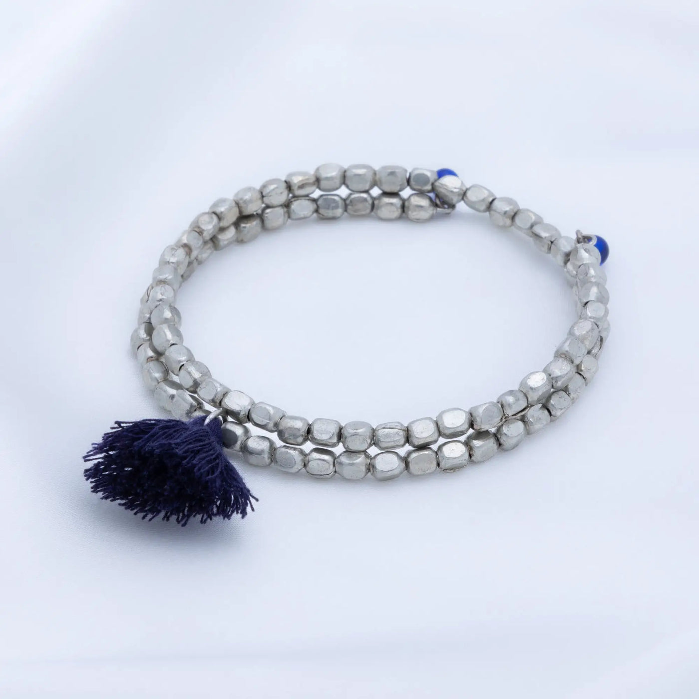 Silver beaded Taj tassel metal bead bracelet with a navy blue tassel and small blue accent beads
