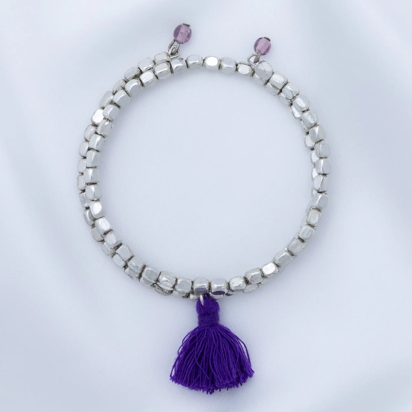 Taj tassel metal bead bracelet with silver beads purple tassel and two small pink beads at the top
