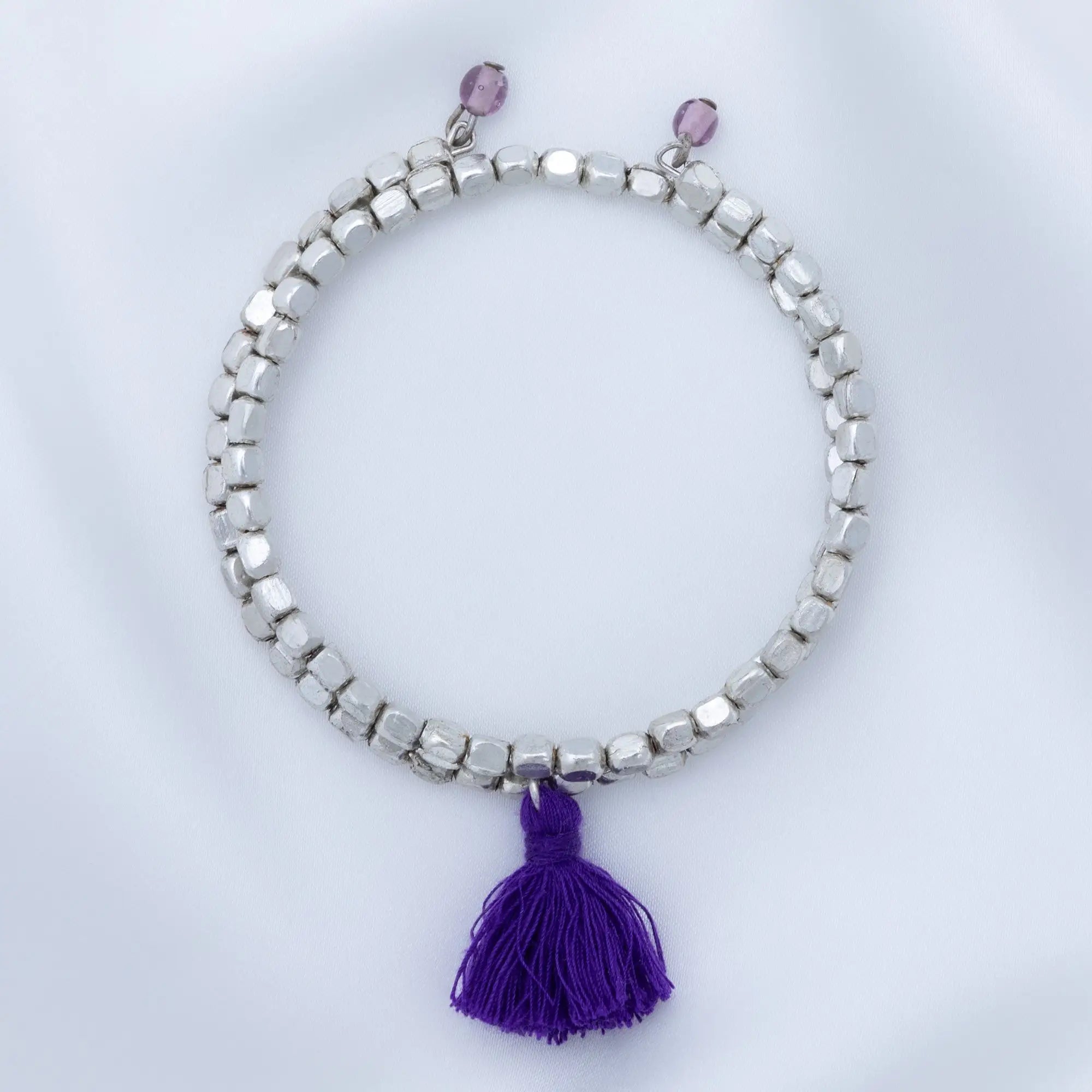 Taj tassel metal bead bracelet with silver beads purple tassel and two small pink beads at the top