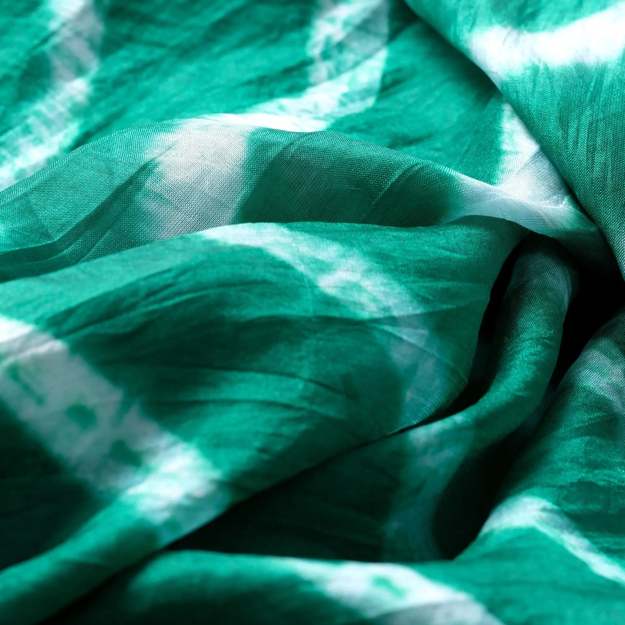 A soft flowing green and white tie-dye silk scarf with a silky texture perfect for stylish wear