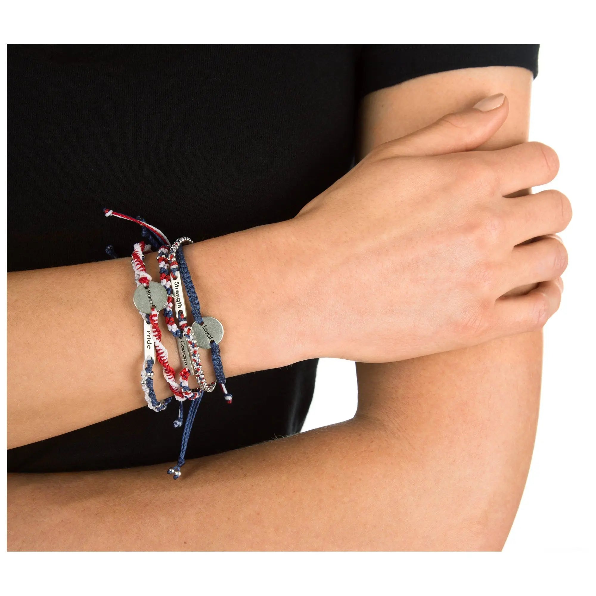 A set of five colorful braided wakami friendship bracelets with metallic charms engraved with strength and hope on a wrist