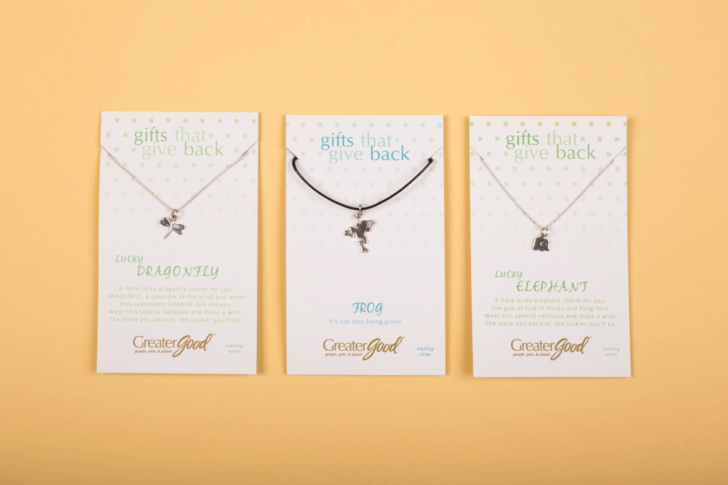Three silver-toned sterling wild at heart necklace pendants shaped as dragonfly frog and elephant on greatergood cards